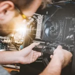 A SotemarTechnology technician repairing a computer at a customer's home in Aruba.