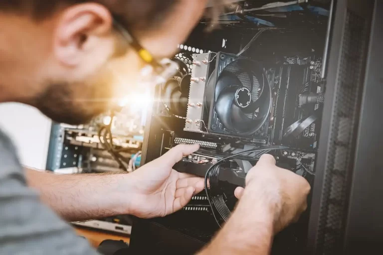 A SotemarTechnology technician repairing a computer at a customer's home in Aruba.